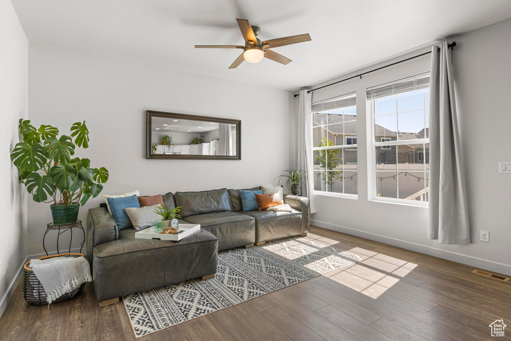 Living area with baseboards, ceiling fan, wood finished floors, and visible vents