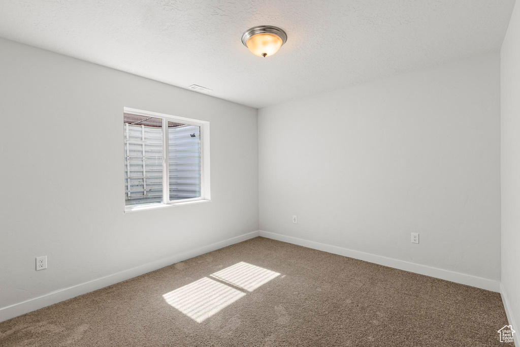 Empty room with baseboards, carpet flooring, and visible vents