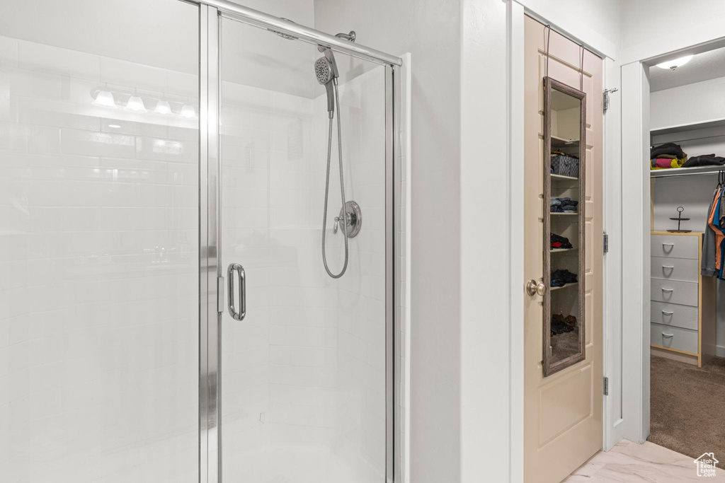 Bathroom with a stall shower and a spacious closet