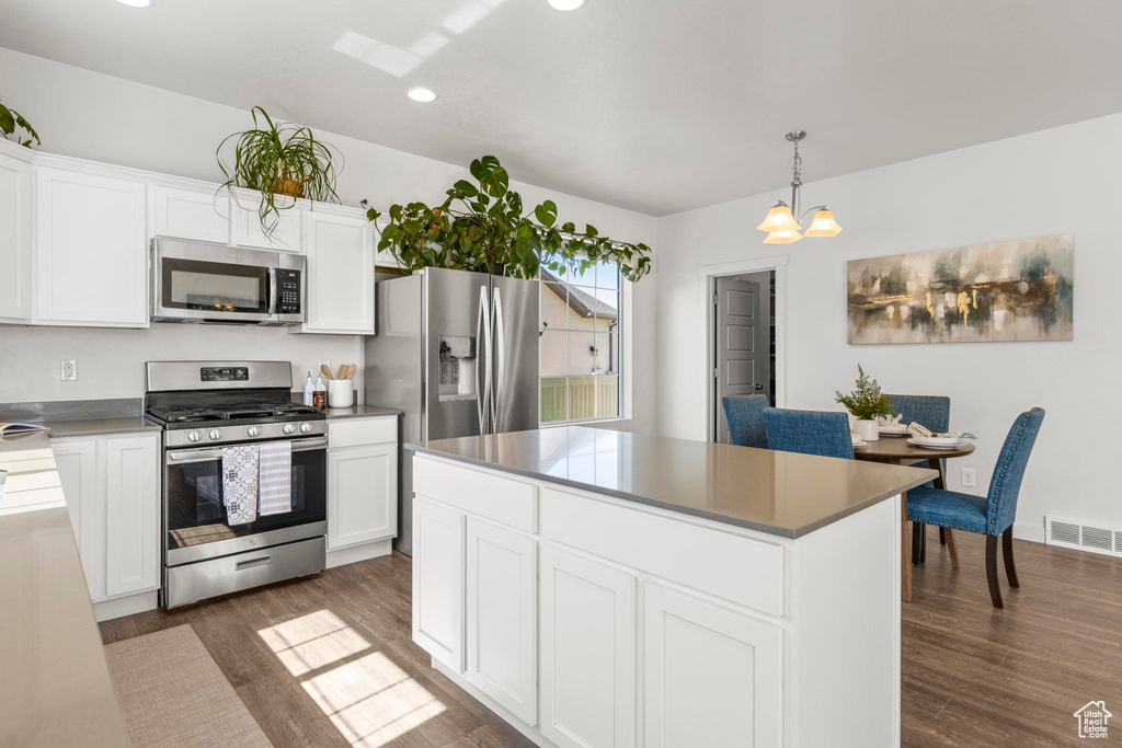 Kitchen with white cabinets, dark wood-style flooring, appliances with stainless steel finishes, recessed lighting, and visible vents