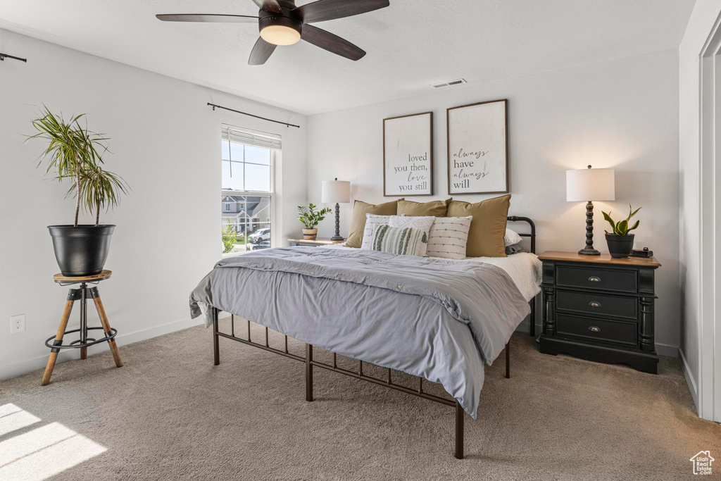 Carpeted bedroom featuring a ceiling fan, baseboards, and visible vents