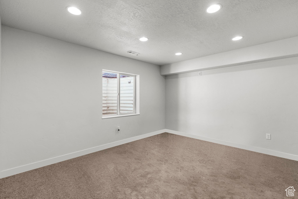 Basement with carpet floors, baseboards, recessed lighting, and a textured ceiling