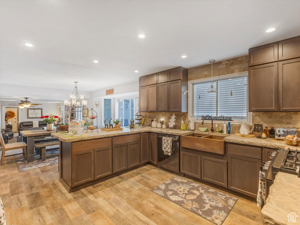 Kitchen with a sink, decorative backsplash, a peninsula, and dishwasher