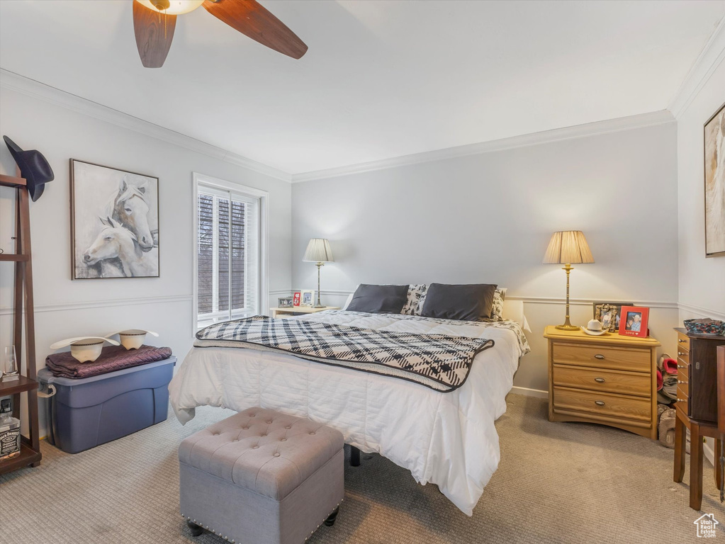 Bedroom featuring carpet floors, ornamental molding, and a ceiling fan