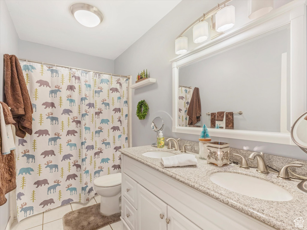 Full bath with tile patterned flooring, a sink, double vanity, and toilet