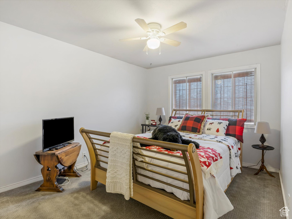 Bedroom with baseboards, carpet flooring, and a ceiling fan