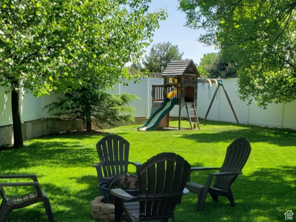 View of yard featuring a playground and a fenced backyard