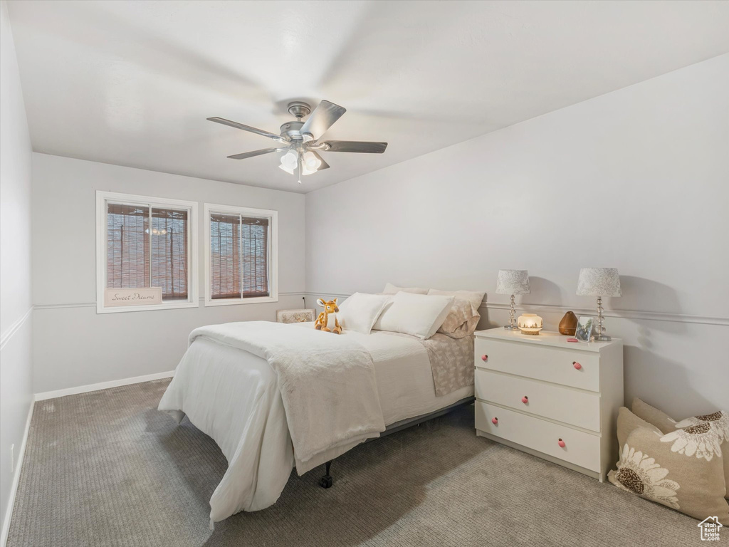Carpeted bedroom featuring a ceiling fan
