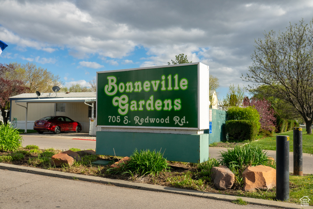 Community sign featuring an attached carport