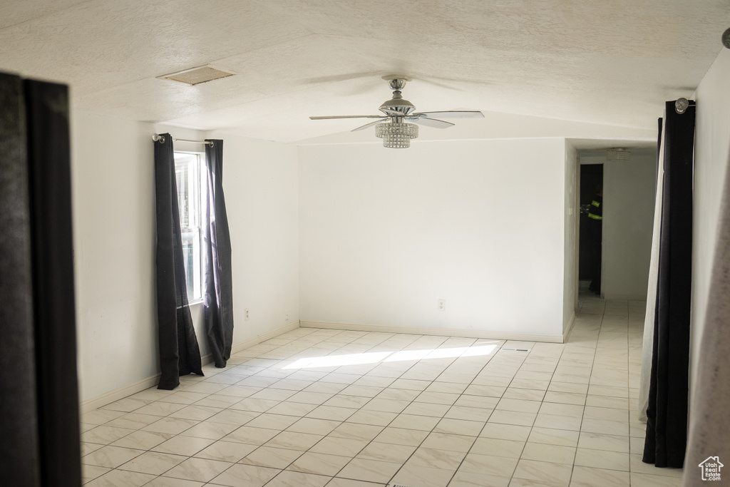 Unfurnished room with visible vents, a ceiling fan, a textured ceiling, and light tile patterned flooring
