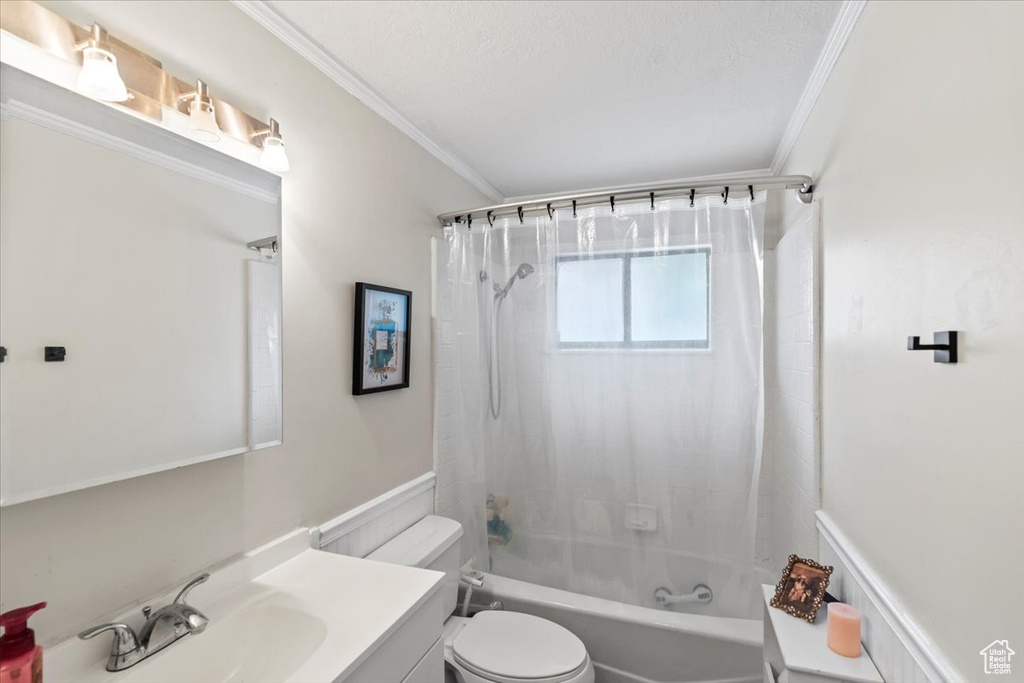 Full bathroom with crown molding, toilet, vanity, and shower / bathtub combination with curtain
