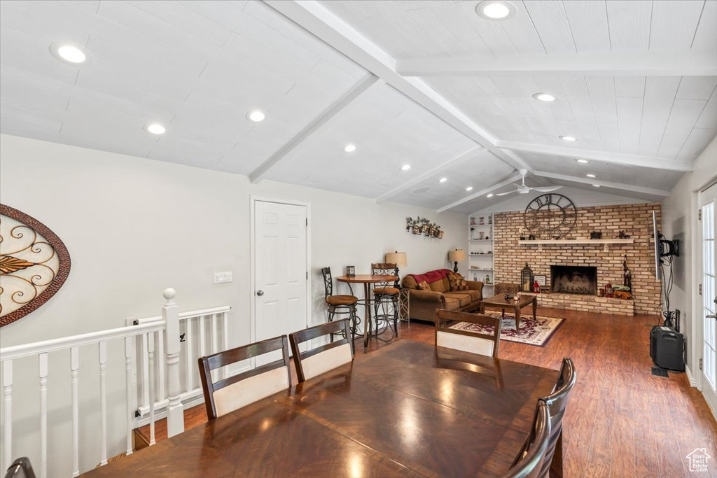 Dining space featuring dark wood-style flooring, ceiling fan, recessed lighting, and a brick fireplace