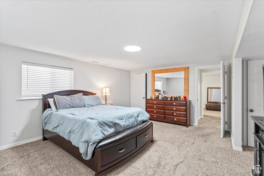 Bedroom with light carpet and baseboards