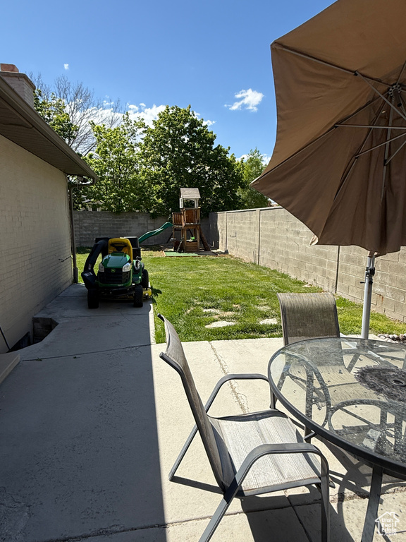 View of patio / terrace featuring a fenced backyard, outdoor dining space, and a playground
