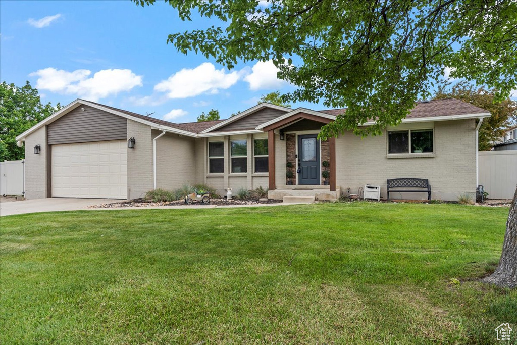 Single story home featuring brick siding, a garage, and driveway