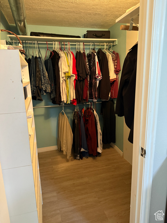 Walk in closet with wood finished floors