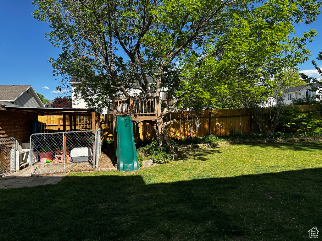 View of yard featuring fence and a playground