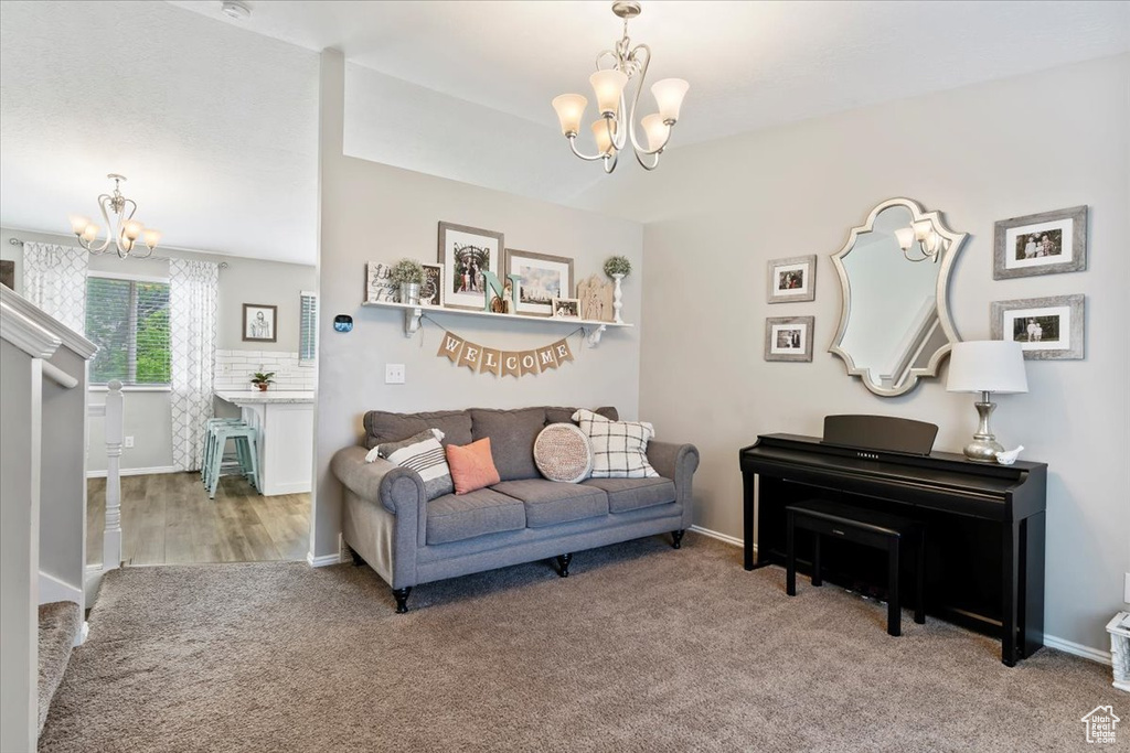 Living area with an inviting chandelier, carpet flooring, and baseboards