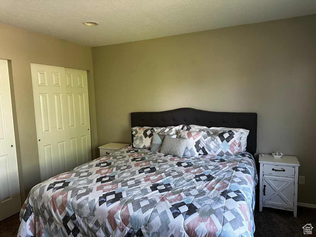 Bedroom featuring dark colored carpet