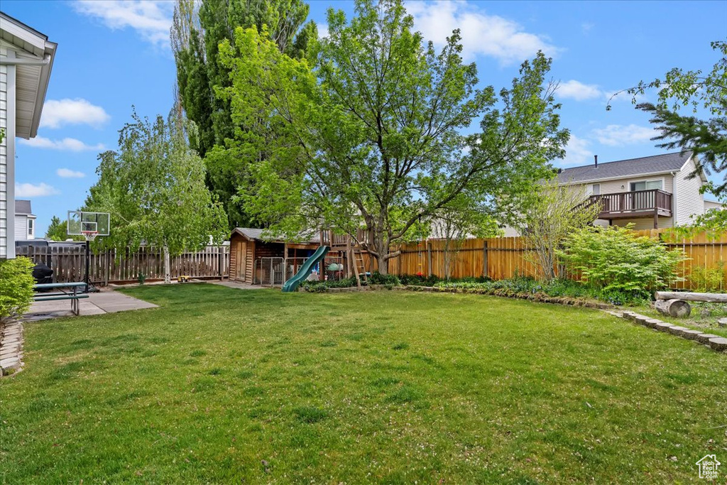 View of yard with an outdoor structure, a patio, a fenced backyard, and a storage unit