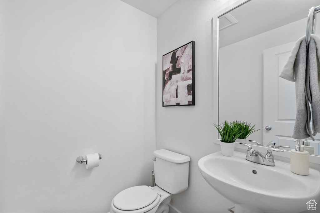 Bathroom featuring baseboards, a sink, and toilet
