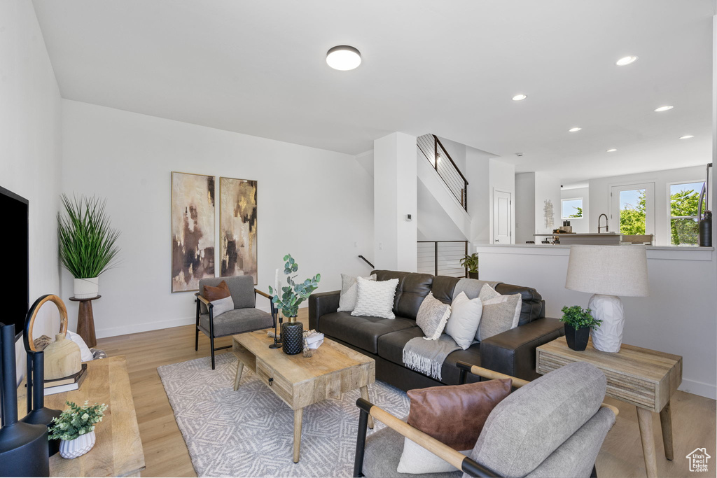 Living area featuring recessed lighting, baseboards, and light wood-style flooring