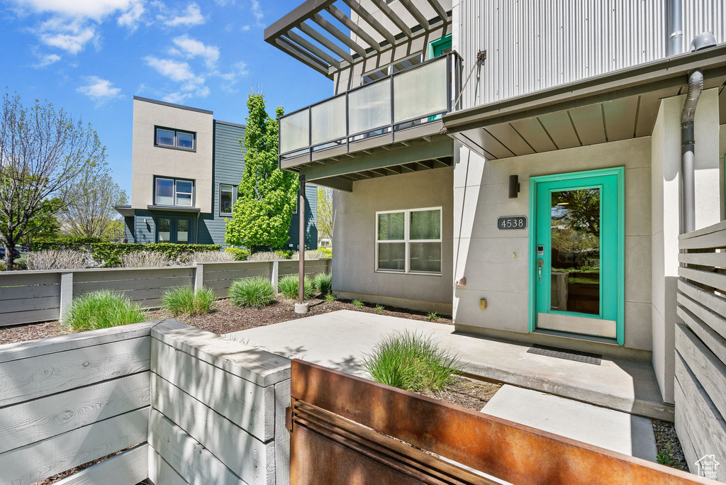 Doorway to property with a patio, fence, and a balcony