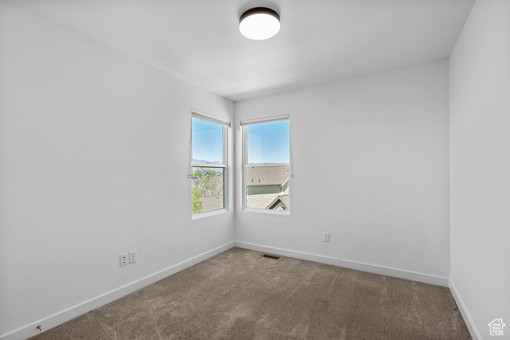 Unfurnished room featuring carpet flooring, baseboards, and visible vents