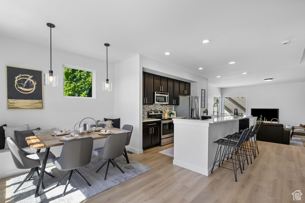 Kitchen with stainless steel appliances, light wood finished floors, open floor plan, and a wealth of natural light