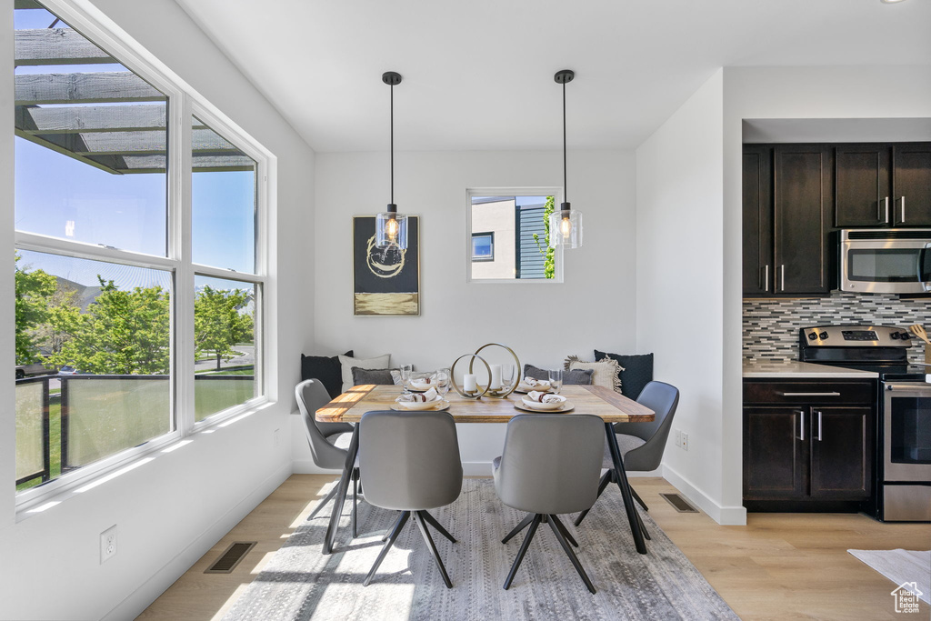 Dining room featuring baseboards, visible vents, and light wood-type flooring