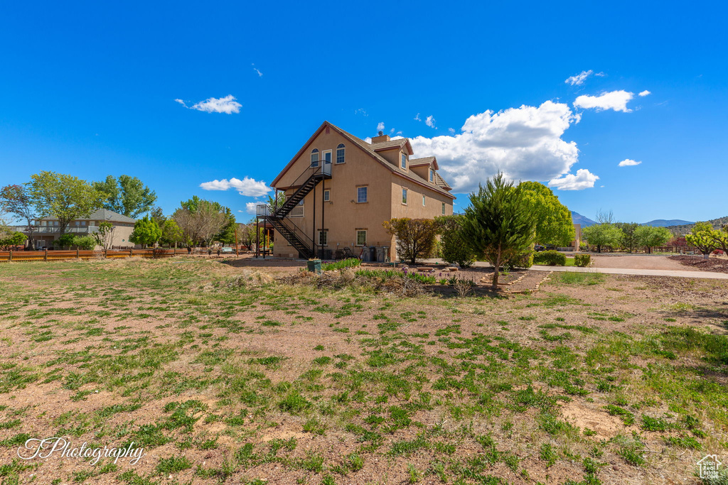 View of home's exterior with stairway, a mountain view, and stucco siding