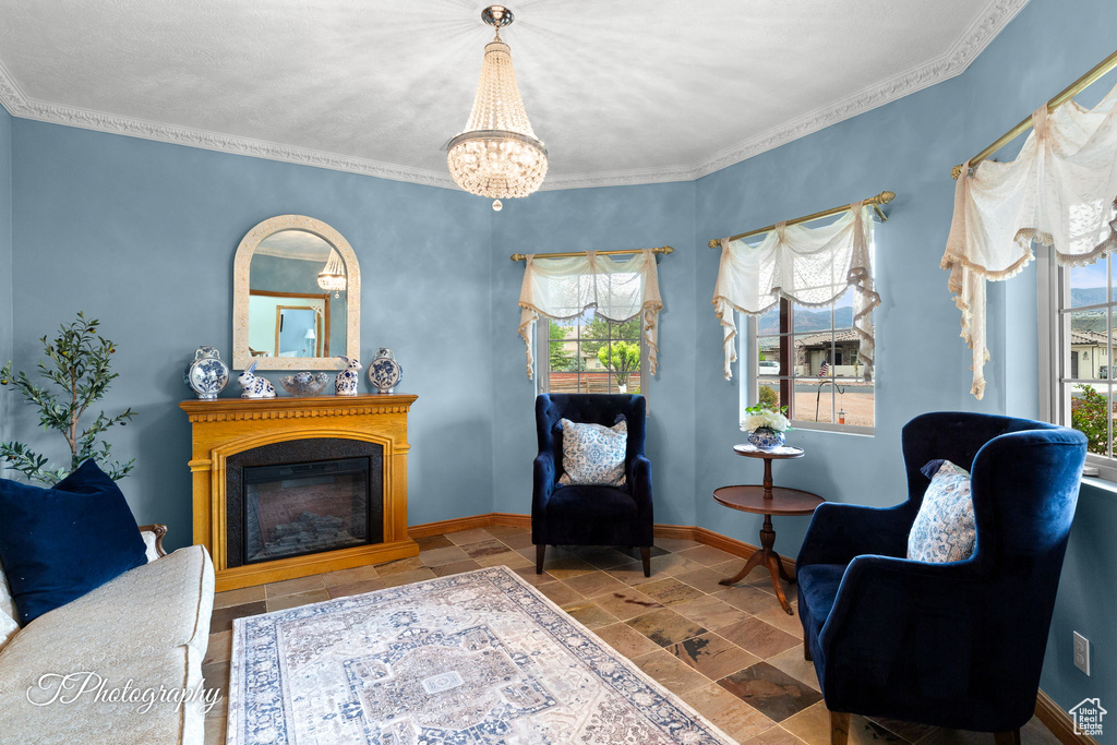 Living area featuring baseboards, stone tile floors, a glass covered fireplace, and a healthy amount of sunlight