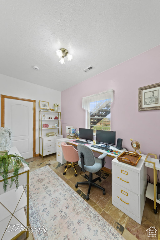 Office with a textured ceiling and visible vents