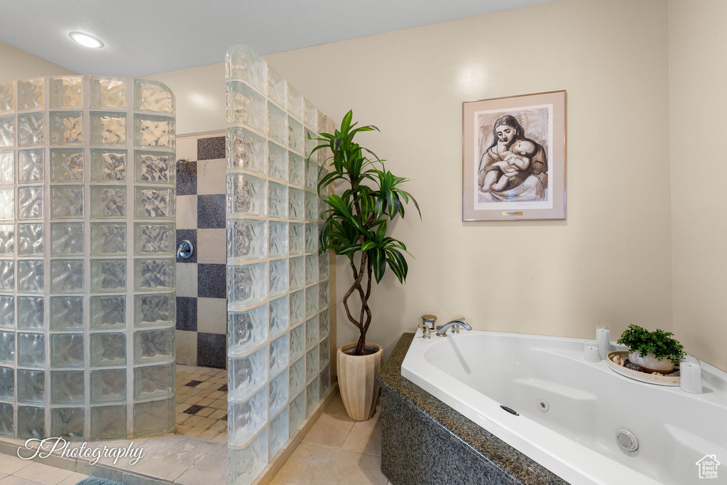 Full bathroom with a jetted tub, a walk in shower, and tile patterned flooring