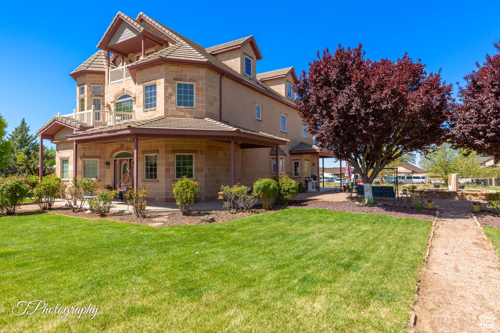 View of front of house with stone siding and a front lawn