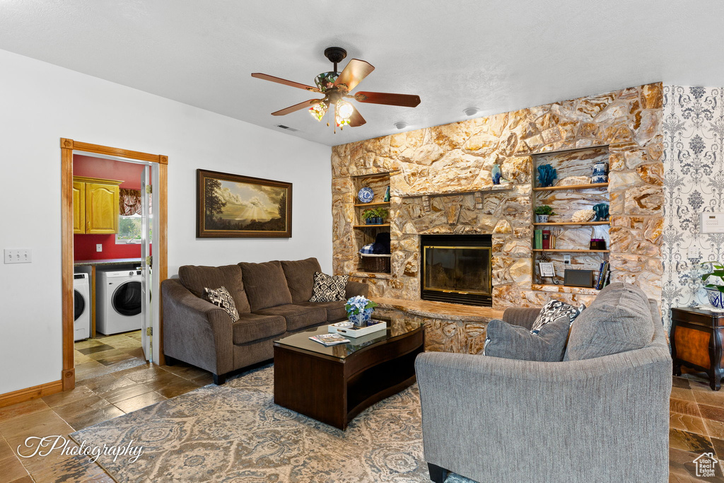 Living room with separate washer and dryer, ceiling fan, a fireplace, and baseboards
