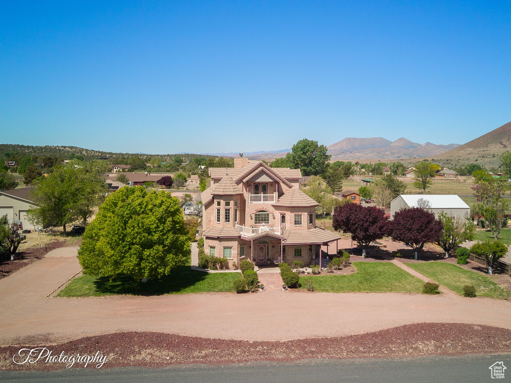 Tudor house featuring a mountain view, a tiled roof, and a front yard