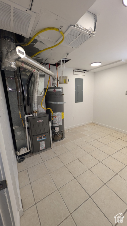 Below grade area with water heater, heating unit, electric panel, and light tile patterned flooring