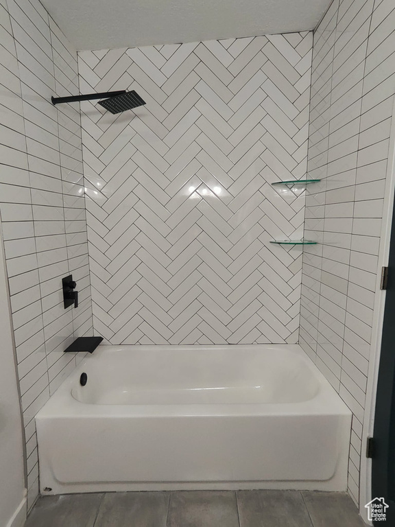 Bathroom with tile patterned floors and shower / bath combination