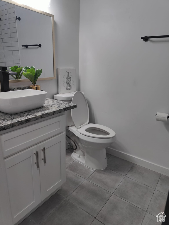 Bathroom with vanity, tile patterned floors, toilet, and baseboards