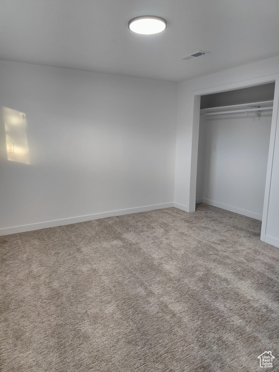 Unfurnished bedroom with a closet, carpet flooring, and baseboards