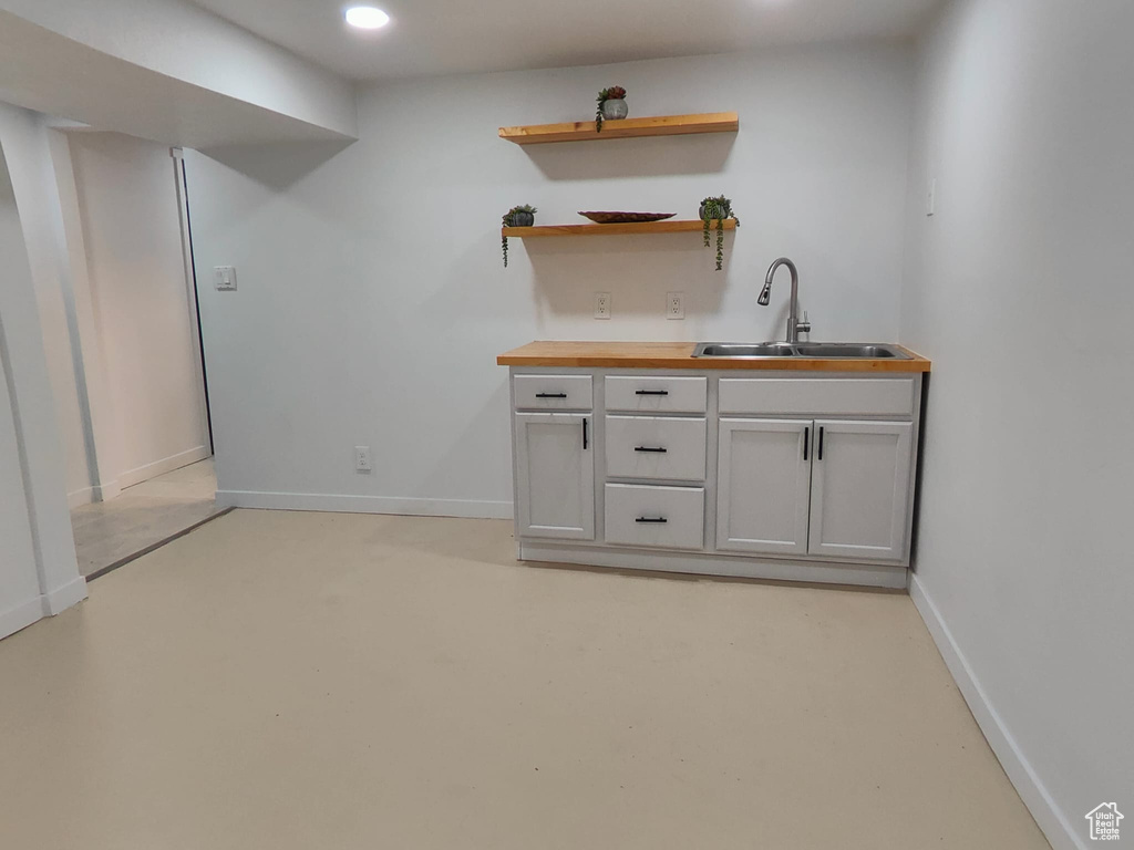 Bar with a sink, baseboards, and recessed lighting