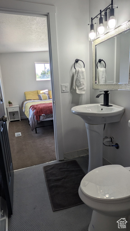 Bathroom with baseboards, ensuite bathroom, and toilet