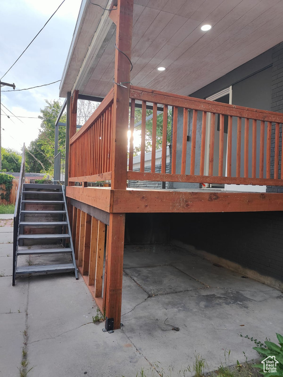 View of side of home with stairway and a deck
