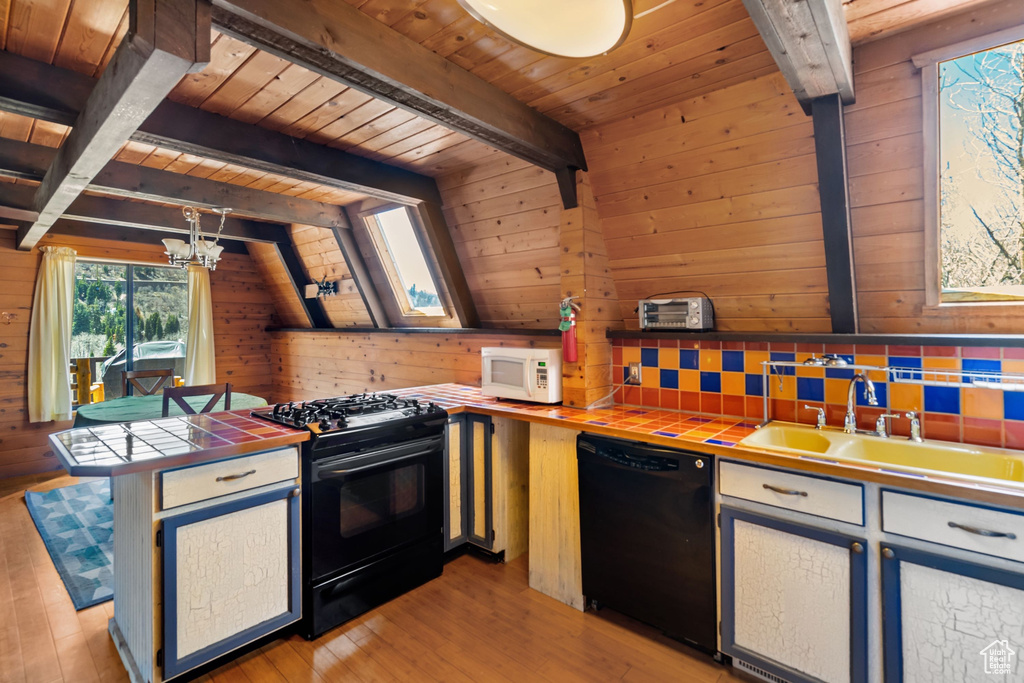 Kitchen featuring tile countertops, beam ceiling, a sink, wooden ceiling, and black appliances