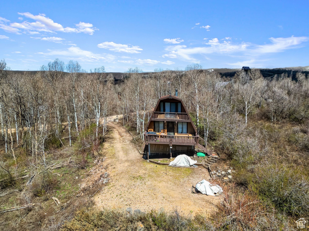Rear view of house with a wooden deck and a balcony