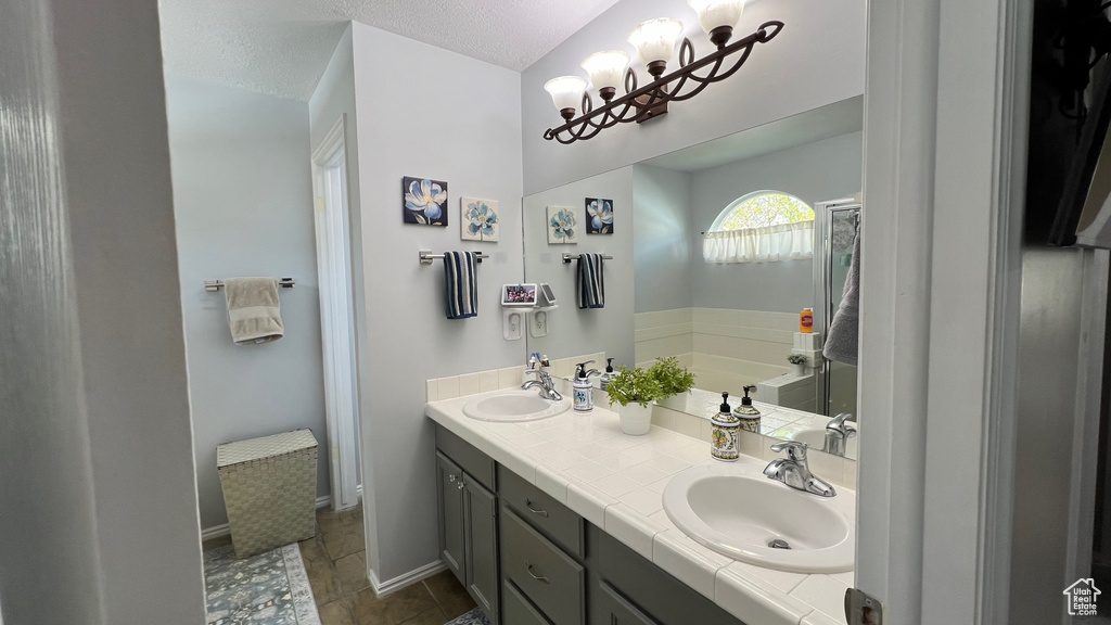 Bathroom with a sink, a garden tub, double vanity, and a chandelier