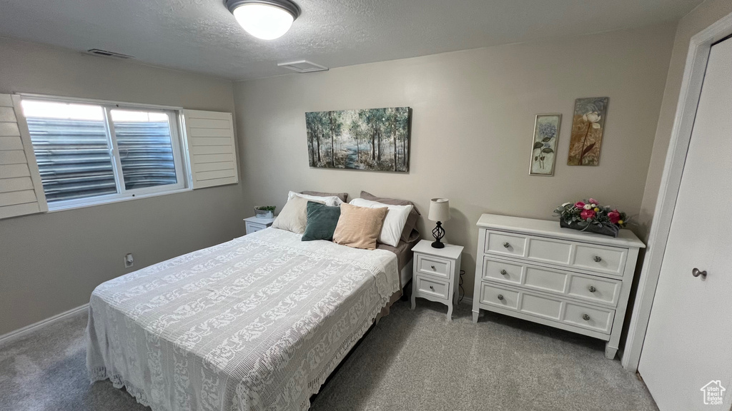 Bedroom featuring carpet, a textured ceiling, and visible vents