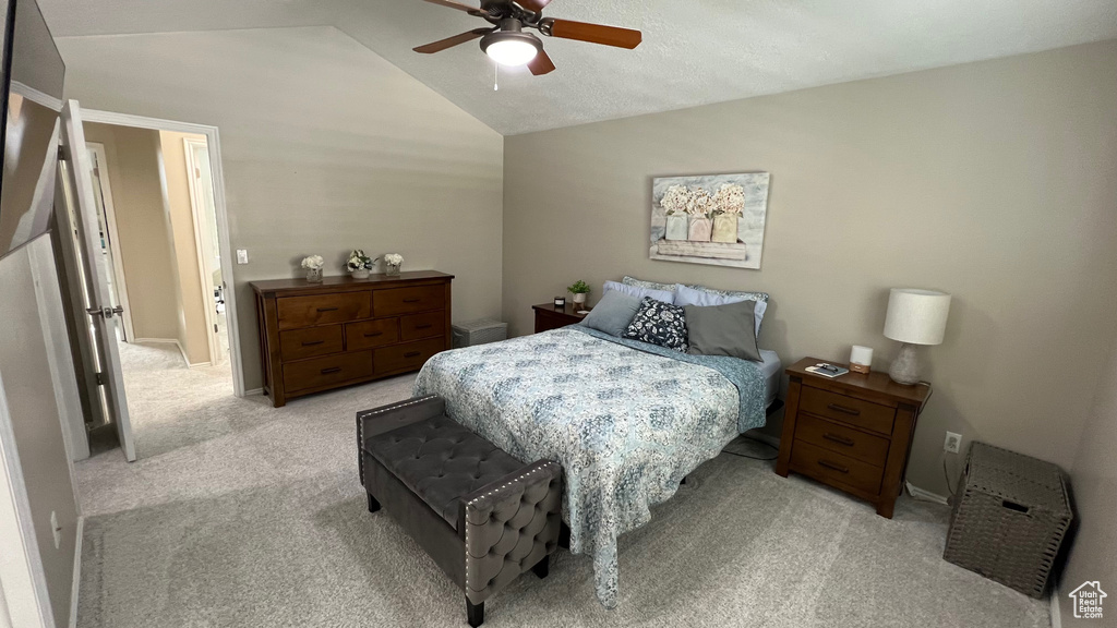 Bedroom featuring light colored carpet, a ceiling fan, and vaulted ceiling