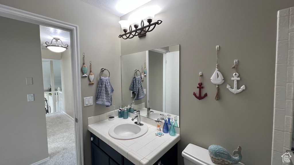 Bathroom featuring vanity, baseboards, and toilet